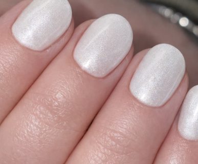 Close-up of Cloud Dancer shimmering gel polish on natural nails.