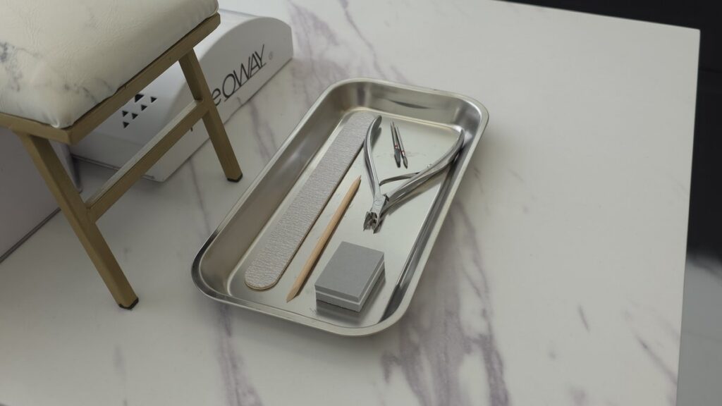 Stainless steel tool tray on marble manicure station at Aesthete Beauty Dundee